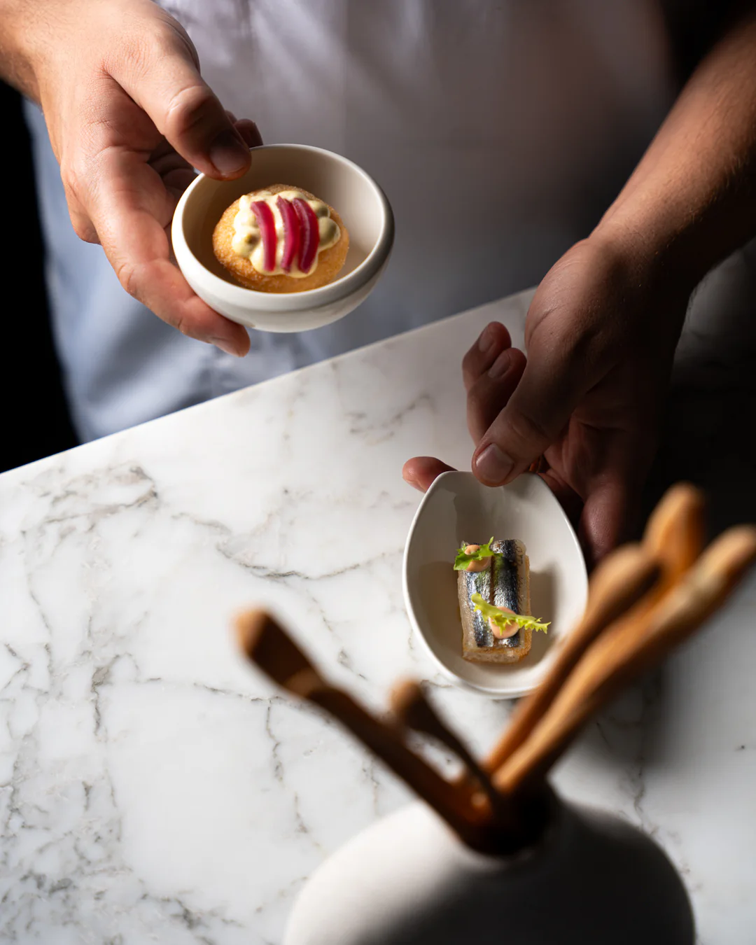 Amuse-bouche e grissini artigianali sul marmo