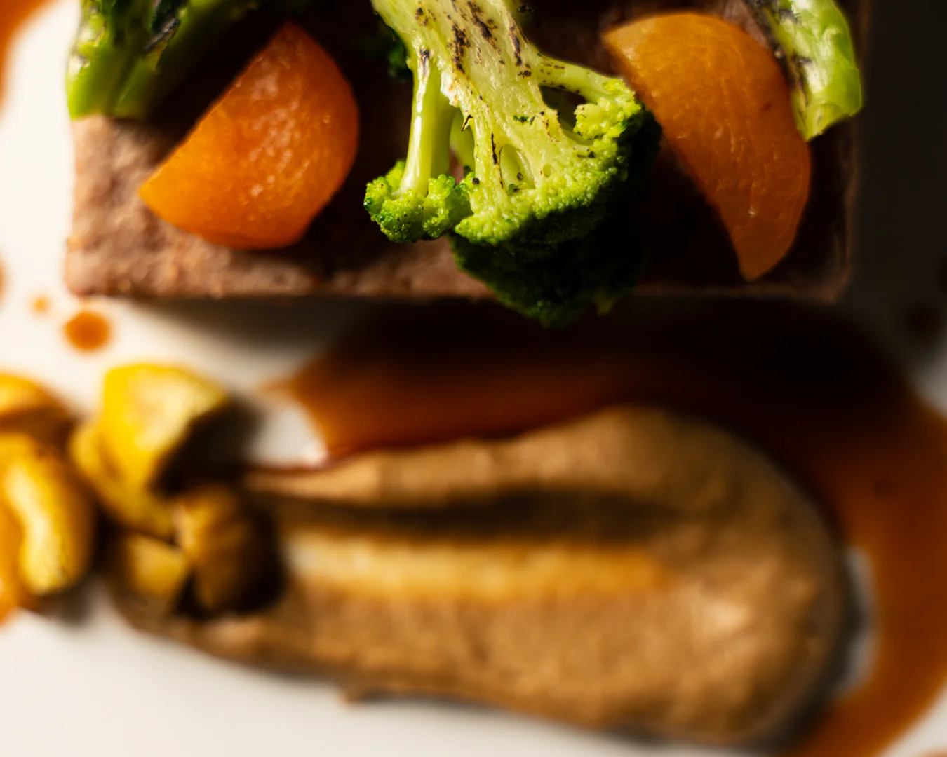 Dettaglio del cosciotto d'agnello con broccoletto, albicocche semi-dry e purè di topinambur