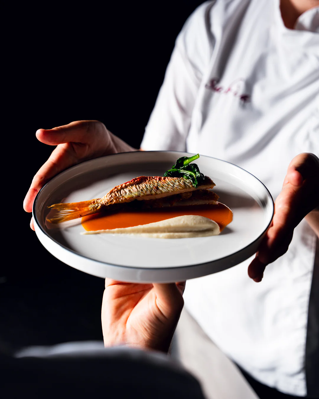 Lo chef porta in sala un piatto della cucina di Sabìa